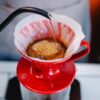 hot coffee preparing in bright red cup with special equipment